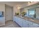 Bathroom with a double sink vanity, granite countertop, large mirror, and a separate tub area with a window view at 320 Coronado Ave, Matthews, NC 28104