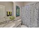 Functional bathroom featuring a single sink with a granite countertop, toilet, and a shower with a patterned curtain at 320 Coronado Ave, Matthews, NC 28104