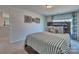 Comfortable bedroom with a striped bedspread, wood accents, natural light, and modern decor at 320 Coronado Ave, Matthews, NC 28104