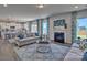 Cozy living room with a fireplace, plush sofas, area rug, and lots of natural light from large windows at 320 Coronado Ave, Matthews, NC 28104