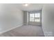 Well-lit bedroom with large window and neutral carpeting at 4113 Black Ct # 167, Harrisburg, NC 28075