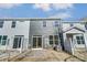 Rear view of townhome with gray siding, stone patio, and fenced yard at 4113 Black Ct # 167, Harrisburg, NC 28075