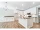 White kitchen cabinetry, center island, and hardwood floors at 4113 Black Ct # 167, Harrisburg, NC 28075