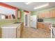 View of kitchen with white appliances, light-colored cabinets, tile floor, and a view to the stairs at 1114 Fenwick Ct, Clover, SC 29710