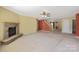 Open living space with a stone fireplace, plush carpeting, and open floor plan to the staircase, kitchen and backyard at 1114 Fenwick Ct, Clover, SC 29710