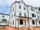 New construction townhome with white siding, black trim, covered front porch and stylish modern architecture at 13013 Moon Rd # 41, Charlotte, NC 28277