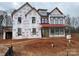 Newly constructed two-story home with red roof and wrap-around porch at 2007 Kendall Dr # 6, Wesley Chapel, NC 28173