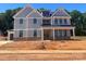 New two-story home with vertical siding, a metal roof, brick accents, and double front doors at 2007 Kendall Dr # 6, Wesley Chapel, NC 28173