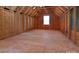 Unfinished attic space with exposed beams, plywood subfloor, and natural light from a window at 3611 Whitney Way, Terrell, NC 28682