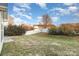This back yard shows a well-maintained lawn with landscaping, a white fence and a stone patio at 11005 Magna Ln, Indian Trail, NC 28079