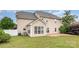 Home exterior view with a lush, green lawn and concrete patio area, plus rear living room at 11005 Magna Ln, Indian Trail, NC 28079
