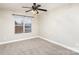 This bedroom features neutral walls, carpet, a dark ceiling fan and a window letting in natural light at 11005 Magna Ln, Indian Trail, NC 28079
