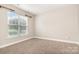 Bright, carpeted bedroom with a large window and neutral walls, offering a blank canvas at 11005 Magna Ln, Indian Trail, NC 28079