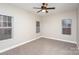 Bright bedroom with three windows, neutral walls and carpeting, and a ceiling fan for added comfort at 11005 Magna Ln, Indian Trail, NC 28079
