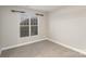 A simple bedroom includes neutral-colored carpet flooring and a window with blinds for adjustable lighting at 11005 Magna Ln, Indian Trail, NC 28079