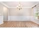 Empty formal dining room features chair rail, chandelier, wood-look floors, and natural light at 11005 Magna Ln, Indian Trail, NC 28079