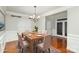 Staged dining room with hardwood floors, wainscoting and chandelier at 11005 Magna Ln, Indian Trail, NC 28079