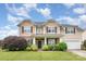 Charming two-story home with a stone facade, well-manicured lawn, and attached two-car garage at 11005 Magna Ln, Indian Trail, NC 28079