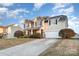 Beautiful two-story home with a well-manicured lawn, a two-car garage, and a welcoming driveway at 11005 Magna Ln, Indian Trail, NC 28079