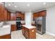Kitchen features dark wood cabinets, an island, and stainless-steel appliances at 11005 Magna Ln, Indian Trail, NC 28079