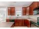 Bright kitchen with wood cabinets, island, black appliances, and plenty of counter space at 11005 Magna Ln, Indian Trail, NC 28079