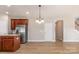 Open-concept kitchen boasts stainless steel appliances, wood cabinets, and stylish light fixture at 11005 Magna Ln, Indian Trail, NC 28079