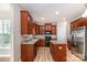 Well-lit kitchen featuring wood cabinets, stainless steel refrigerator, and an island at 11005 Magna Ln, Indian Trail, NC 28079