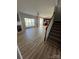 Open concept living area featuring wood floors, a fireplace, and a staircase leading to the upper level at 11005 Magna Ln, Indian Trail, NC 28079