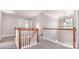 Bright, carpeted staircase featuring classic wood railings and trim, enhancing the home's traditional charm at 11005 Magna Ln, Indian Trail, NC 28079