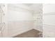 A walk-in closet provides ample shelving for clothing and storage with neutral carpeting and white walls at 11005 Magna Ln, Indian Trail, NC 28079