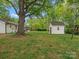 Expansive backyard featuring a storage shed and mature shade tree, offering plenty of room for outdoor activities at 1102 Oak Hill Dr, Monroe, NC 28112