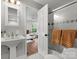 Clean bathroom featuring a pedestal sink and an open view into the Primary bedroom at 1102 Oak Hill Dr, Monroe, NC 28112