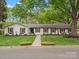 Charming home featuring a manicured lawn, flower boxes, and a painted brick exterior at 1102 Oak Hill Dr, Monroe, NC 28112