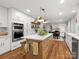 Bright kitchen with an island featuring bar seating and modern stainless steel appliances at 1102 Oak Hill Dr, Monroe, NC 28112