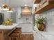 Kitchen with island seating, wooden shelves, new appliances, and stylish overhead lighting at 1102 Oak Hill Dr, Monroe, NC 28112