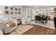 Bright living room featuring hardwood floors, neutral colors, and modern, comfortable seating near dining area at 1102 Oak Hill Dr, Monroe, NC 28112