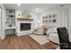 Cozy living room with a brick fireplace, wood mantle, and a sitting area with modern chairs at 1102 Oak Hill Dr, Monroe, NC 28112