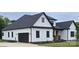 New construction home showcasing a modern farmhouse design with white siding, black trim and a two-car garage at 1215 Coppergate Dr, Salisbury, NC 28147