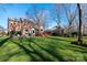 Well-maintained lawn with mature trees and an attractive brick home with outdoor living spaces at 13101 Whisper Creek Dr, Charlotte, NC 28277