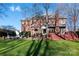 Expansive backyard view showcasing a red brick home, lush lawn, and an inviting outdoor living space at 13101 Whisper Creek Dr, Charlotte, NC 28277