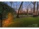 Idyllic backyard at twilight features a quaint garden trellis and bench seating at 13101 Whisper Creek Dr, Charlotte, NC 28277