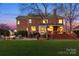 Twilight view of a well-manicured lawn, brick home, and inviting outdoor living spaces at 13101 Whisper Creek Dr, Charlotte, NC 28277