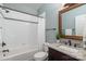 Well-lit bathroom featuring a shower-tub combo with white tile surround and granite vanity at 13101 Whisper Creek Dr, Charlotte, NC 28277
