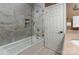 Bathroom featuring marble-look shower tiles and glass doors, complete with a white door at 13101 Whisper Creek Dr, Charlotte, NC 28277