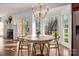 Cozy breakfast nook with round table, chandelier, and large windows overlooking wooded backyard at 13101 Whisper Creek Dr, Charlotte, NC 28277