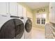 Bright laundry room boasts modern washer and dryer, and ample storage space with clean white cabinets at 13101 Whisper Creek Dr, Charlotte, NC 28277