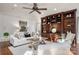 Bright living room features hardwood floors, a ceiling fan, large custom wood shelving and comfortable seating at 13101 Whisper Creek Dr, Charlotte, NC 28277