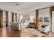 Large main bedroom features a tray ceiling, hardwood floors, and bright windows with lush curtains at 13101 Whisper Creek Dr, Charlotte, NC 28277