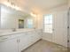 Bright bathroom features double vanity, tiled floors, large mirrors, and bright natural light at 165 Halite Ln, Waxhaw, NC 28173