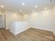 Spacious bonus room features light wood floors and white walls with modern recessed lighting throughout at 165 Halite Ln, Waxhaw, NC 28173